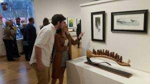 Couple looks at visual art on the walls of the Chessman Gallery