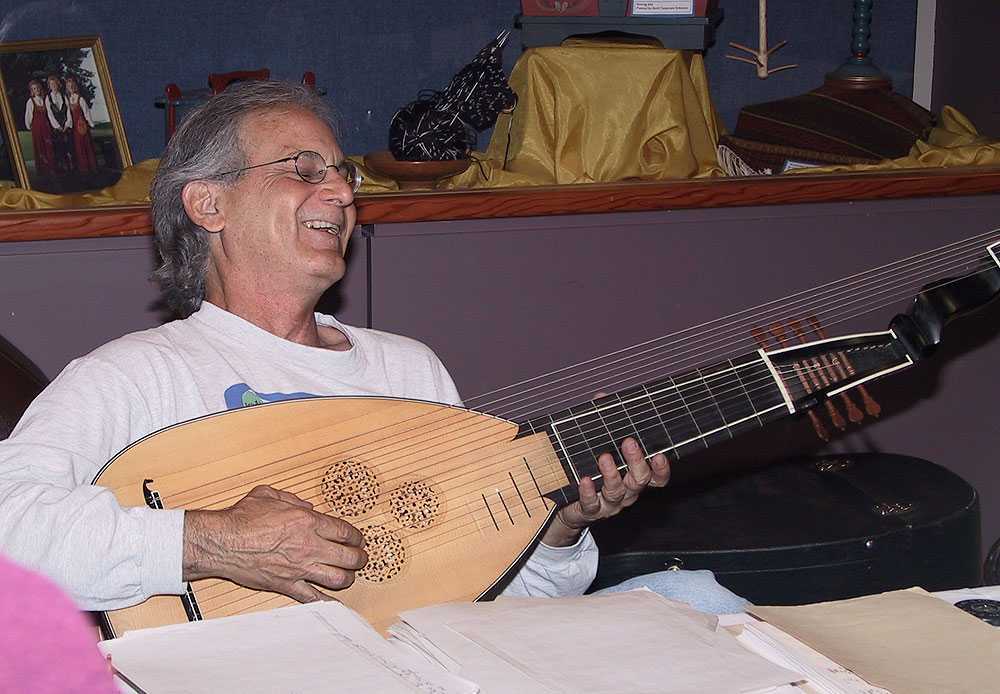 Terry Schumacher smiling while playing the lute