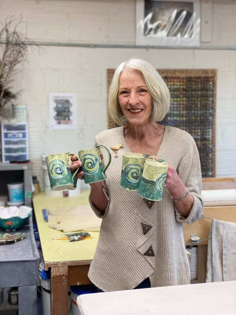 Ceramics artist Pam Young poses with this year's LCCC Donor Appreciation mugs she created.