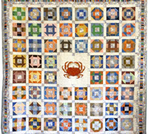 Quilt full of geometric shapes and a large crab in the center